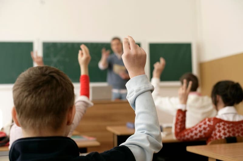Học sinh giơ tay phát biểu trong giờ học