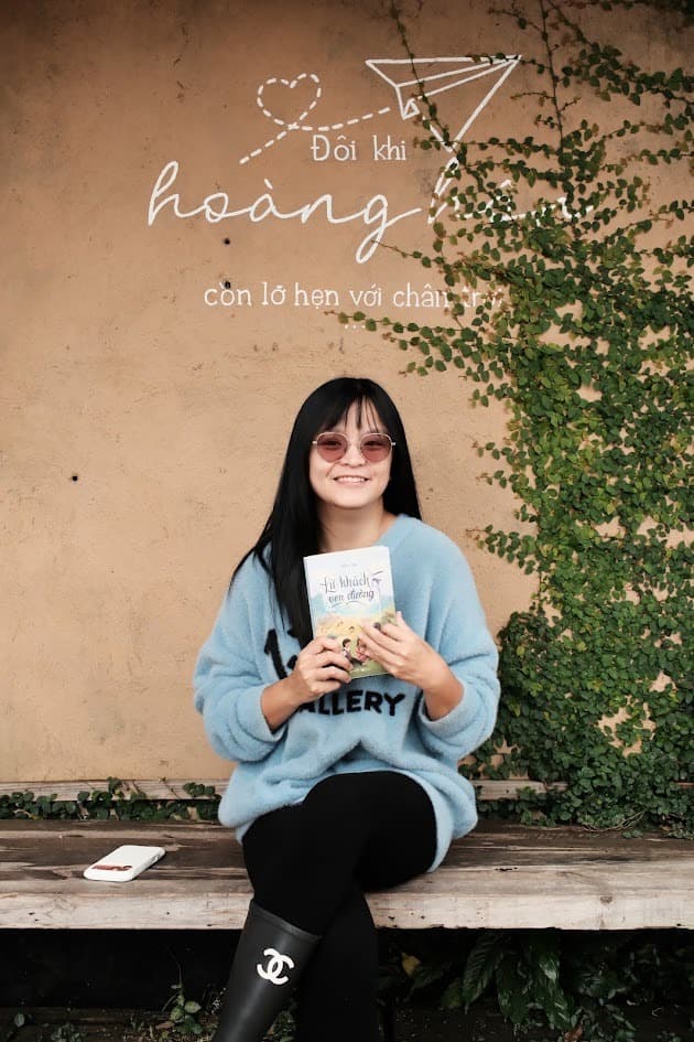Ms. Hiếu Ngô cầm sách và mỉm cười