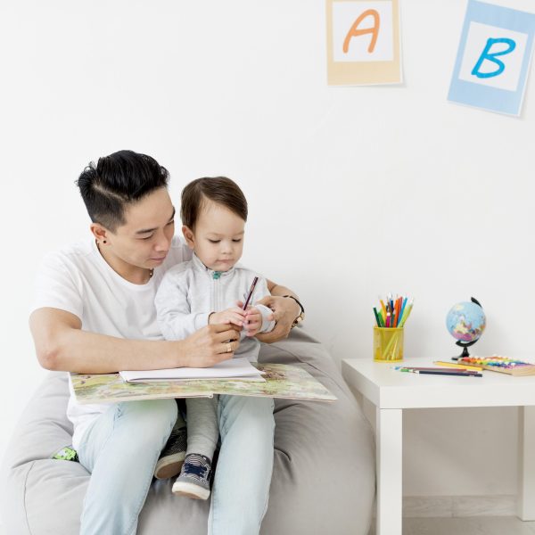 man-drawing-with-child-while-home